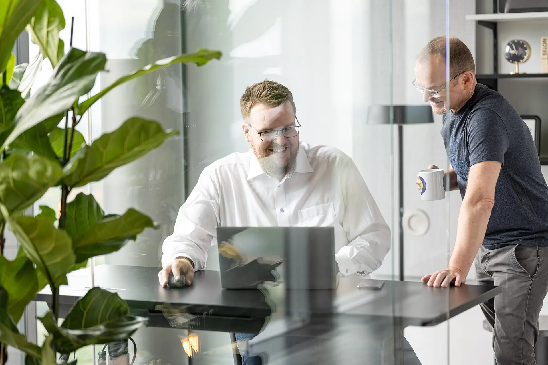 Two Cloudfalke consultants collaborating at a modern office desk with a laptop